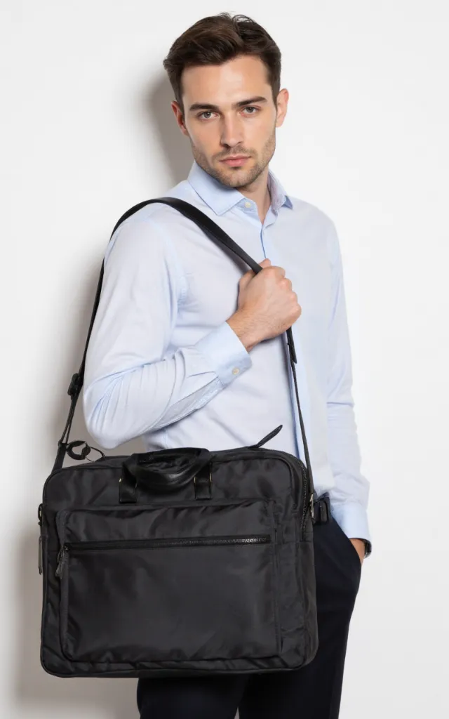 A French male model with a Nylon   lined briefcase, wearing a shirt, against a white background, in a front   facing close   up